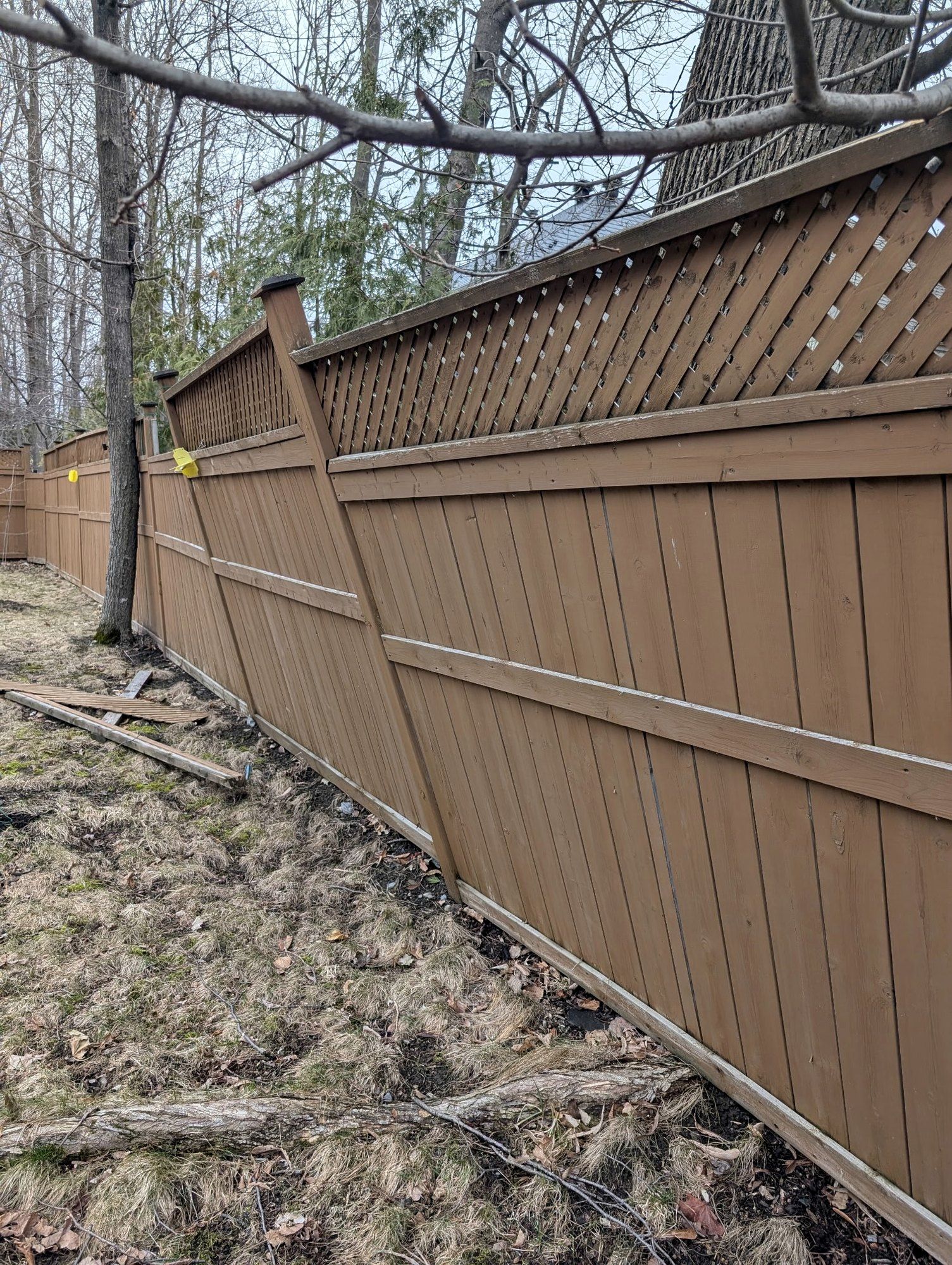 Before: Leaning wood fence straightened