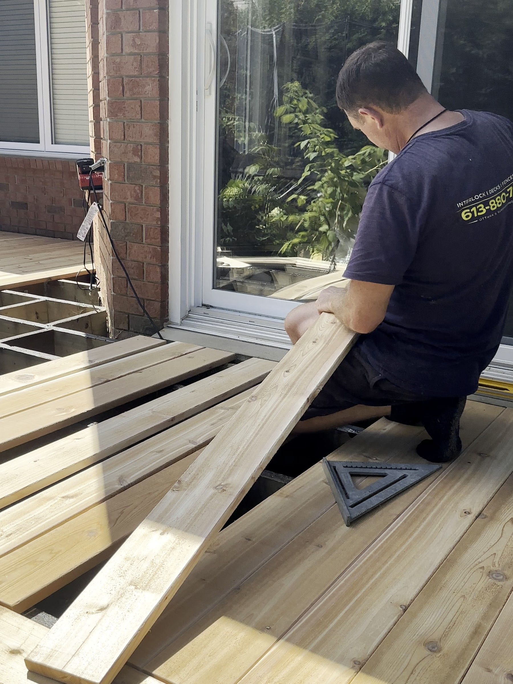 Korvex crew member laying cedar deck boards beside a patio door