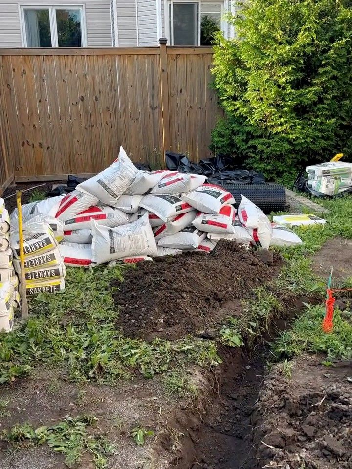 Trench dug past the stockpiled stone