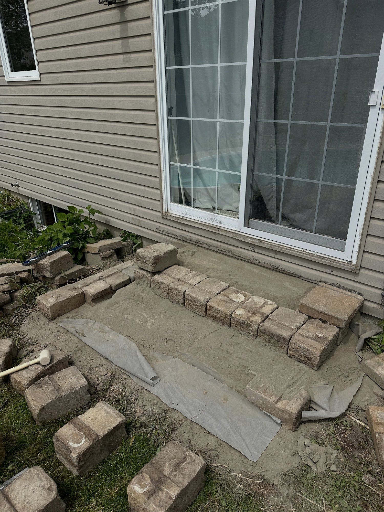 First course of segmental block set on a new base at a patio door