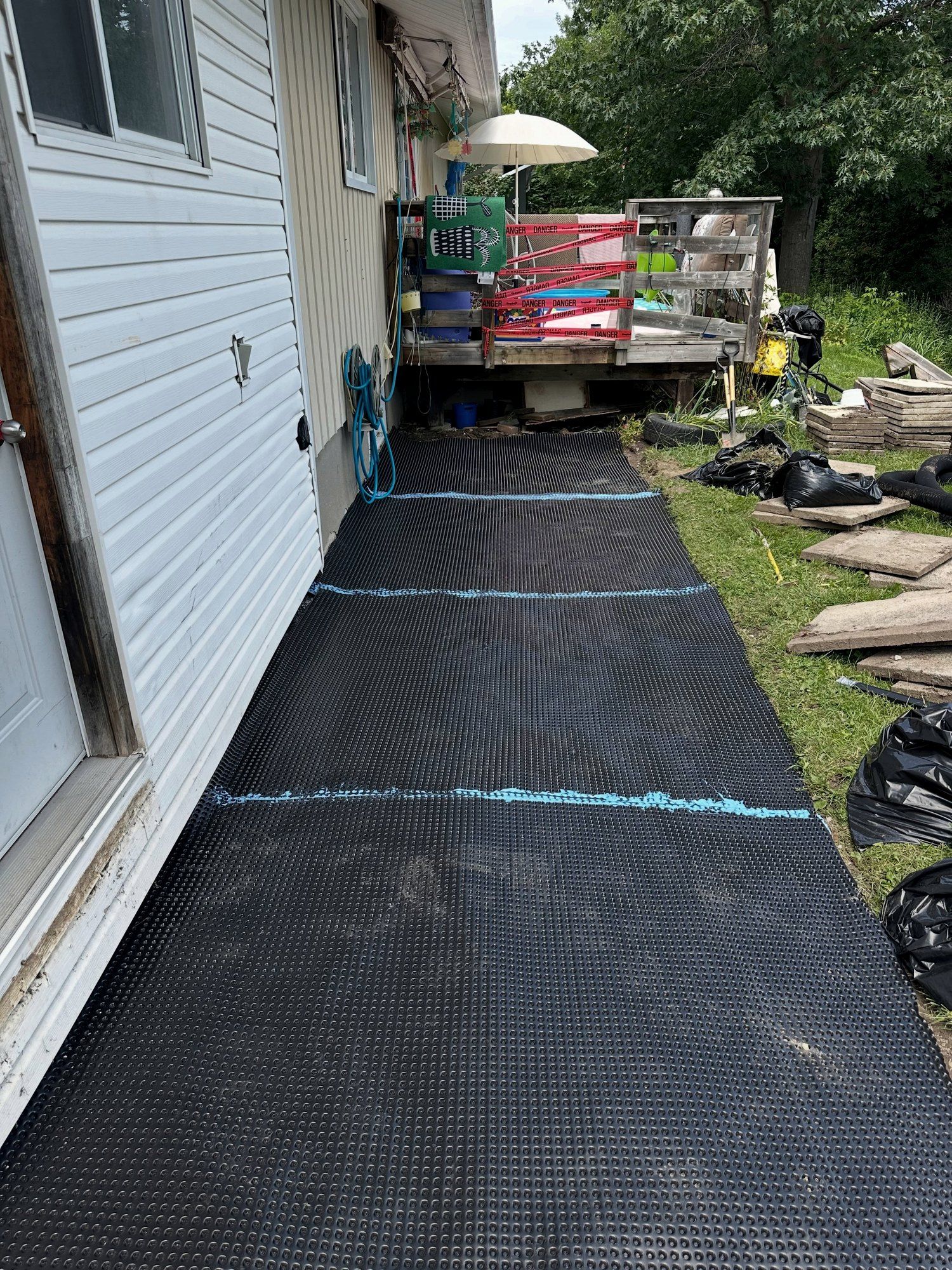 Dimpled drainage membrane laid along a foundation
