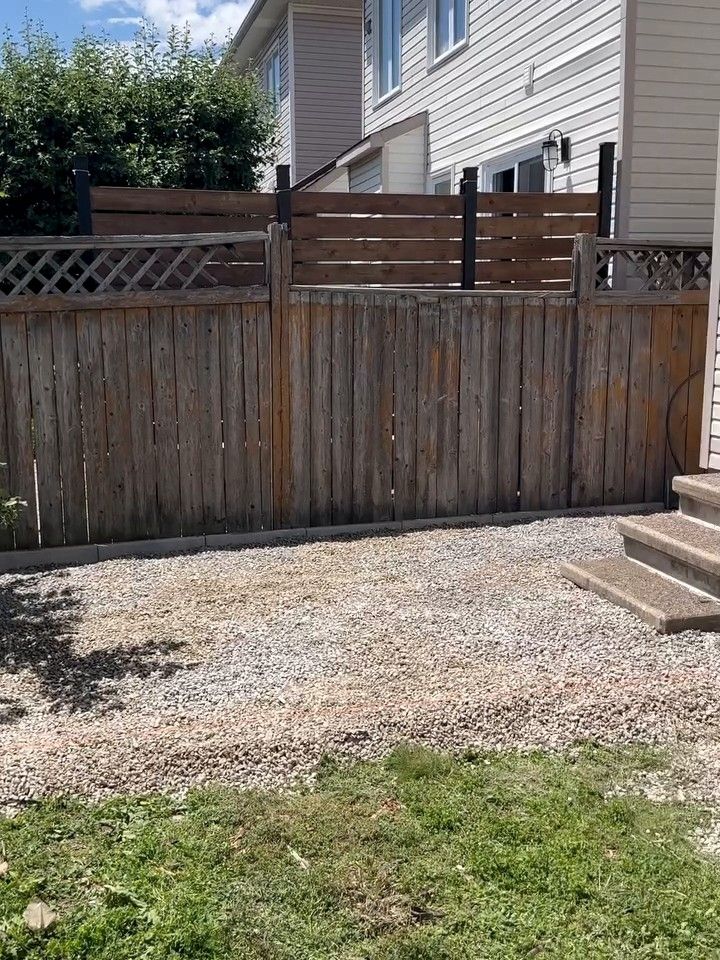 Clear-stone strip along the back wall of a house, beside a wood fence