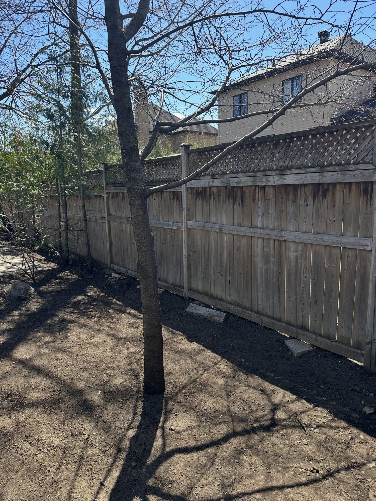 Long wood fence with a lattice top standing straight again after repair