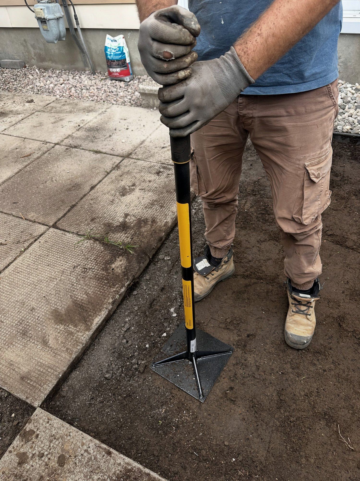 Base compacted by hand along a patio edge