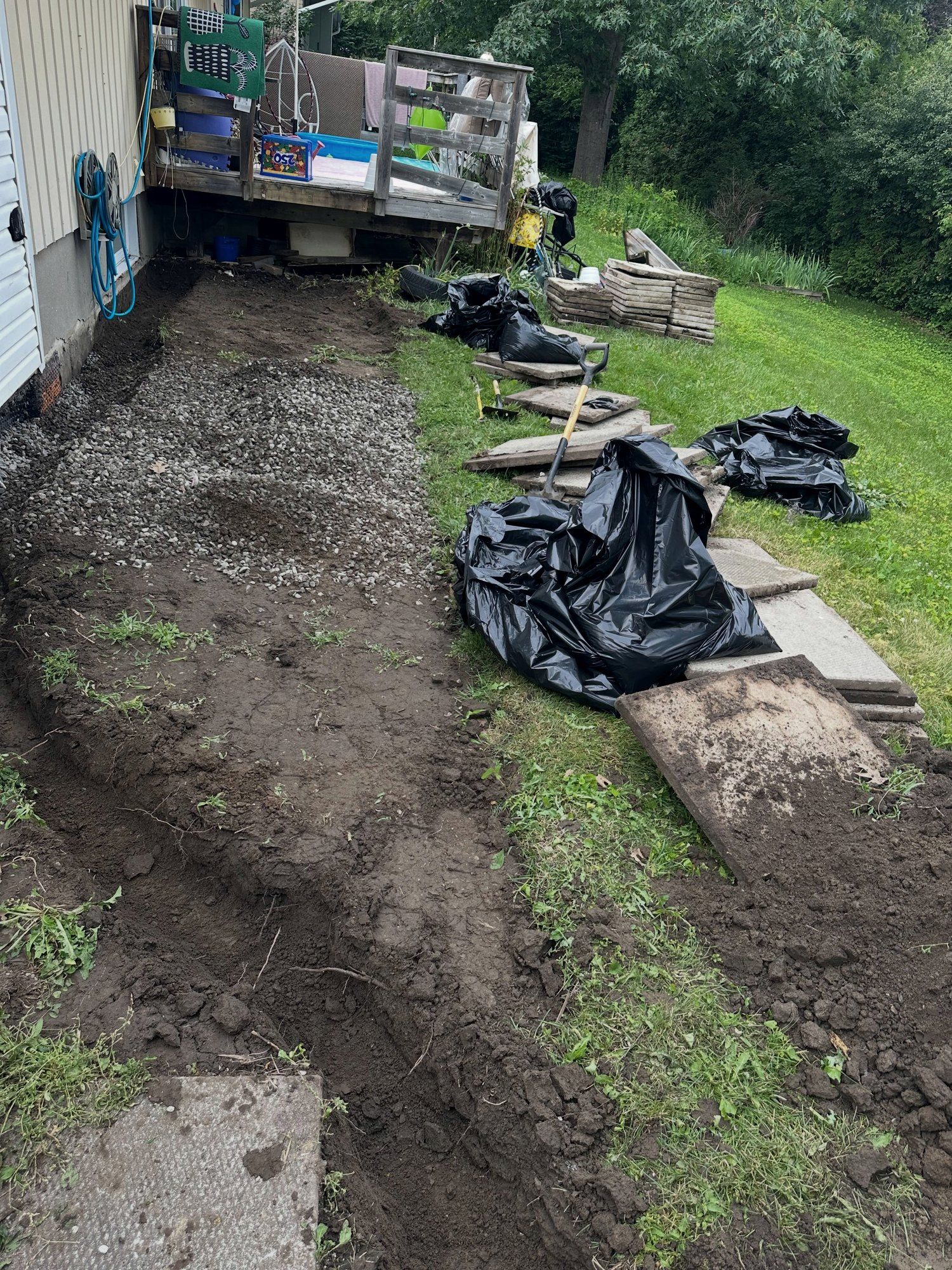 Excavated drainage trench along the side of a house