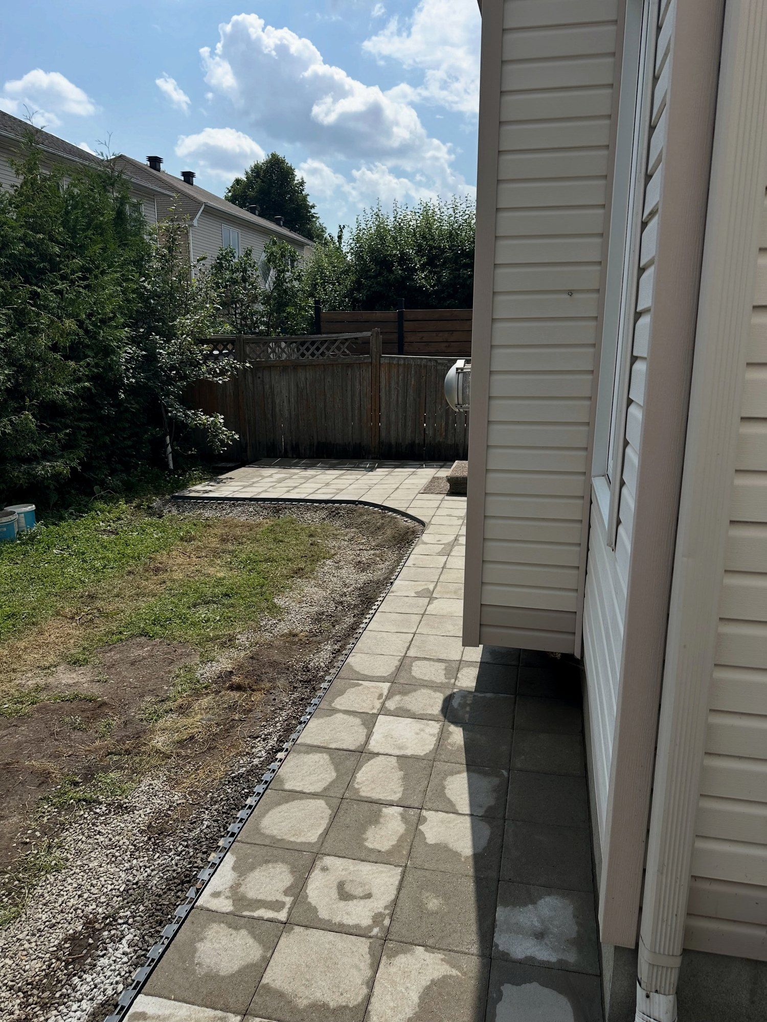 New paver walkway laid along the side of a house, running from the driveway to the backyard